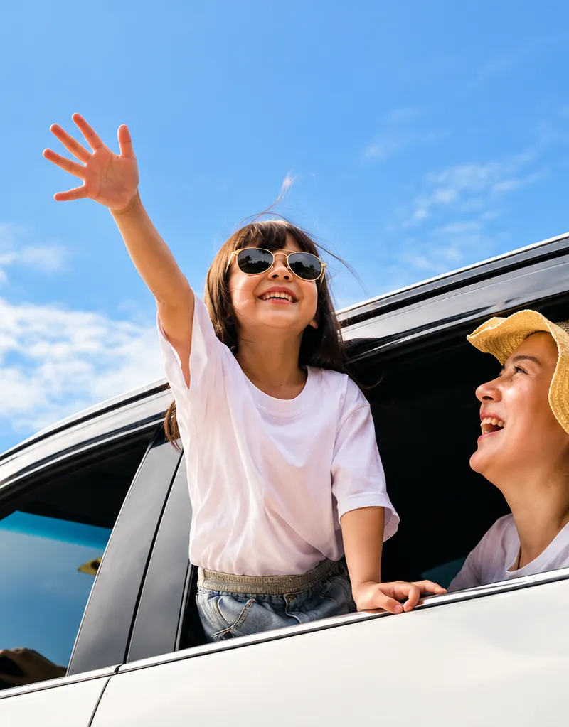 Niña feliz asomada a la ventanilla de un coche