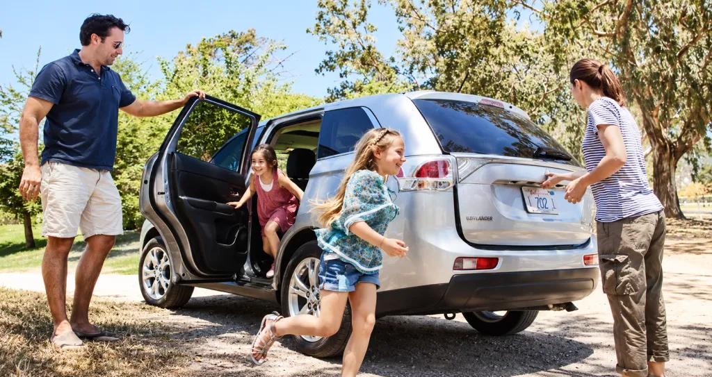Familia subiendo a un coche de alquiler